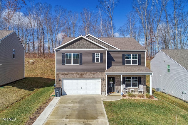 view of front of home with a garage, a front yard, and covered porch