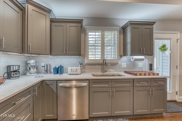 kitchen featuring sink, stainless steel dishwasher, gray cabinets, and a healthy amount of sunlight