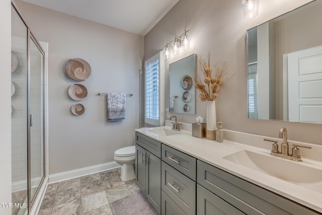 bathroom featuring toilet, a shower with door, and vanity