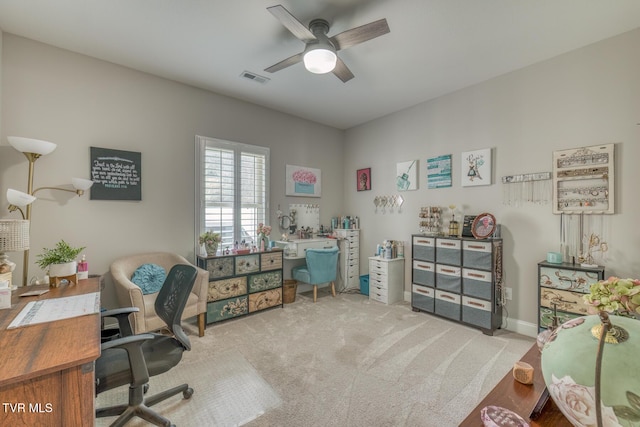 carpeted office space featuring ceiling fan