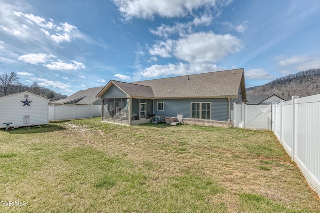 back of house featuring a yard and a sunroom