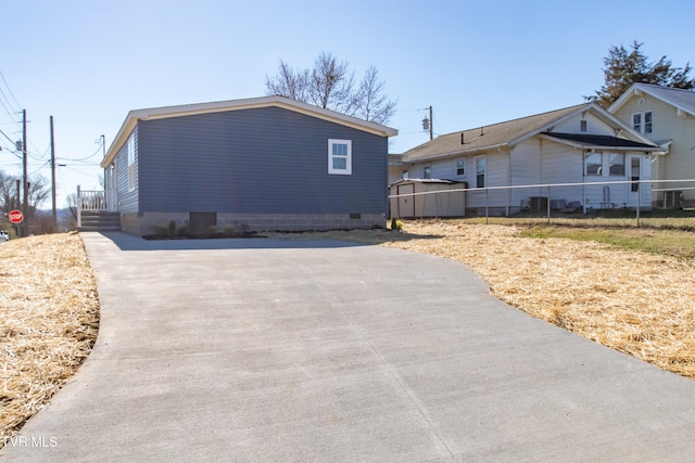 view of side of home with crawl space and fence