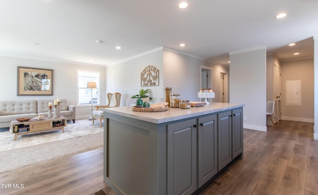 kitchen featuring open floor plan, wood finished floors, a center island, gray cabinets, and light countertops