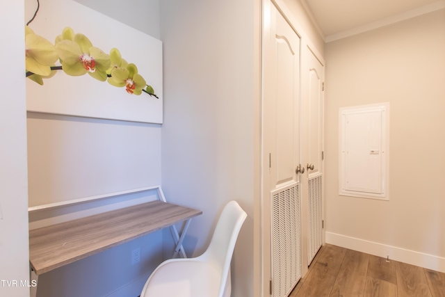 office with electric panel, baseboards, visible vents, wood finished floors, and crown molding