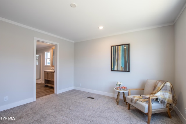 living area featuring ornamental molding, carpet flooring, visible vents, and baseboards