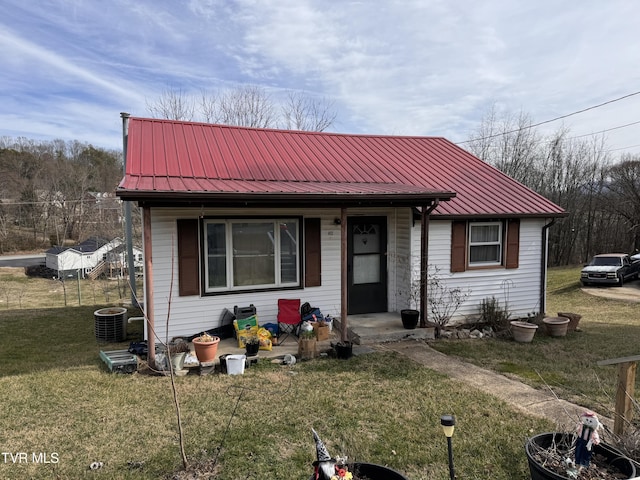 bungalow-style house featuring central AC and a front yard