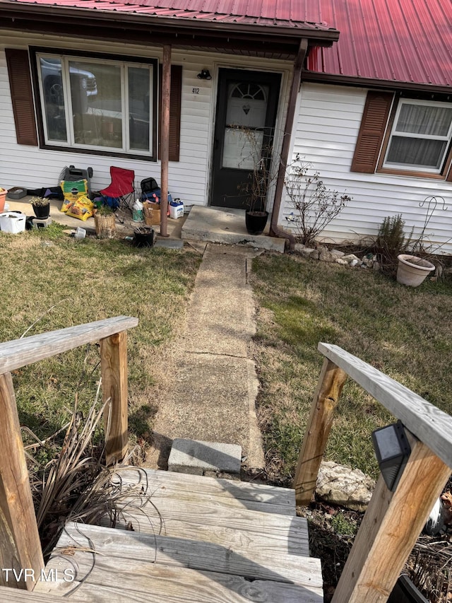 property entrance with a lawn