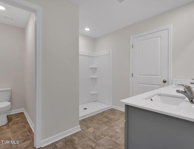 bathroom featuring vanity, toilet, and walk in shower