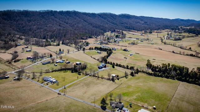 drone / aerial view with a forest view, a mountain view, and a rural view