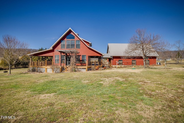 rear view of house with a lawn and a wooden deck