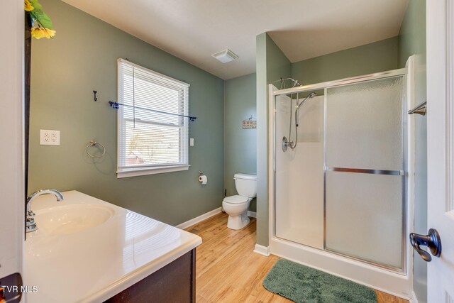 full bath featuring visible vents, toilet, a stall shower, wood finished floors, and baseboards