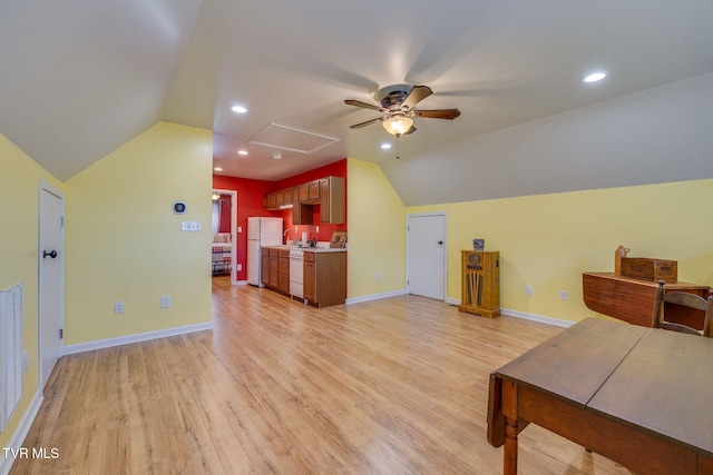 interior space with vaulted ceiling, baseboards, and light wood-style floors