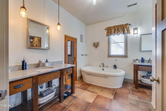 full bath featuring a freestanding tub, visible vents, vanity, and baseboards