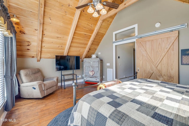 unfurnished bedroom featuring lofted ceiling with beams, a barn door, wood ceiling, visible vents, and hardwood / wood-style floors