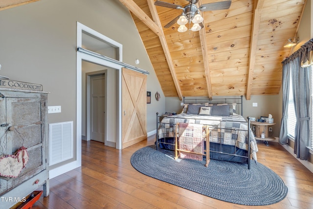 bedroom featuring vaulted ceiling with beams, visible vents, a barn door, wooden ceiling, and hardwood / wood-style floors