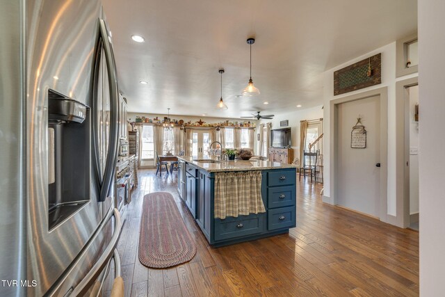 kitchen featuring stainless steel fridge, dark wood finished floors, decorative light fixtures, and blue cabinetry