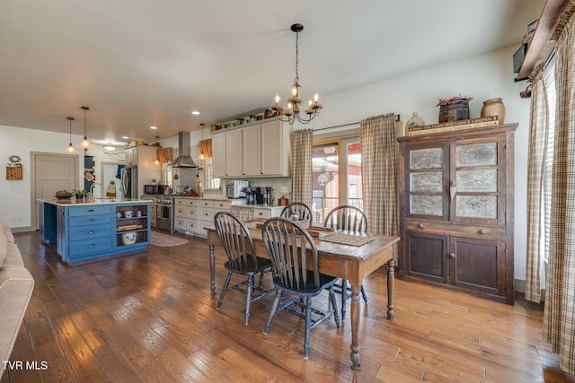 dining room featuring baseboards, hardwood / wood-style floors, and an inviting chandelier