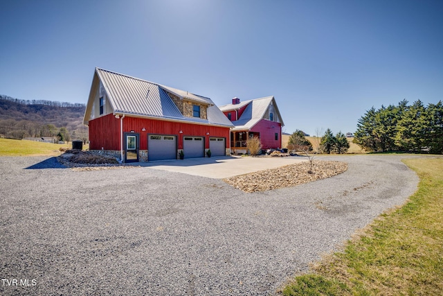 view of front of property with metal roof and concrete driveway