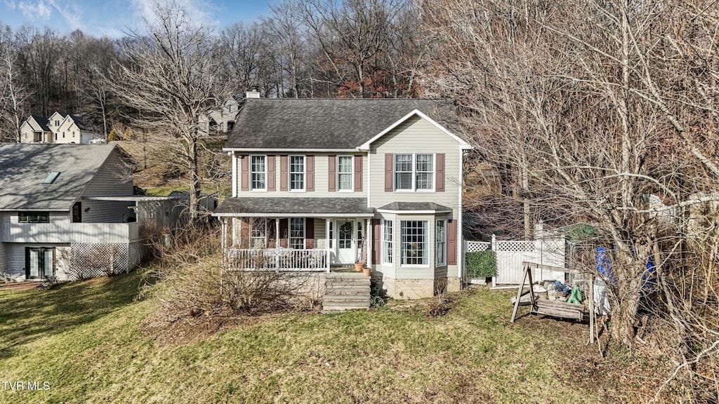 view of front of home with covered porch and a front lawn