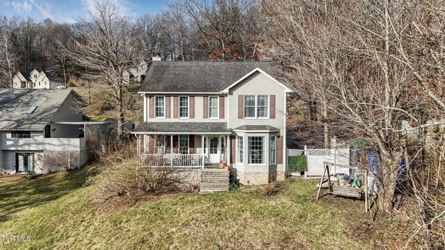 view of front of home with covered porch and a front lawn