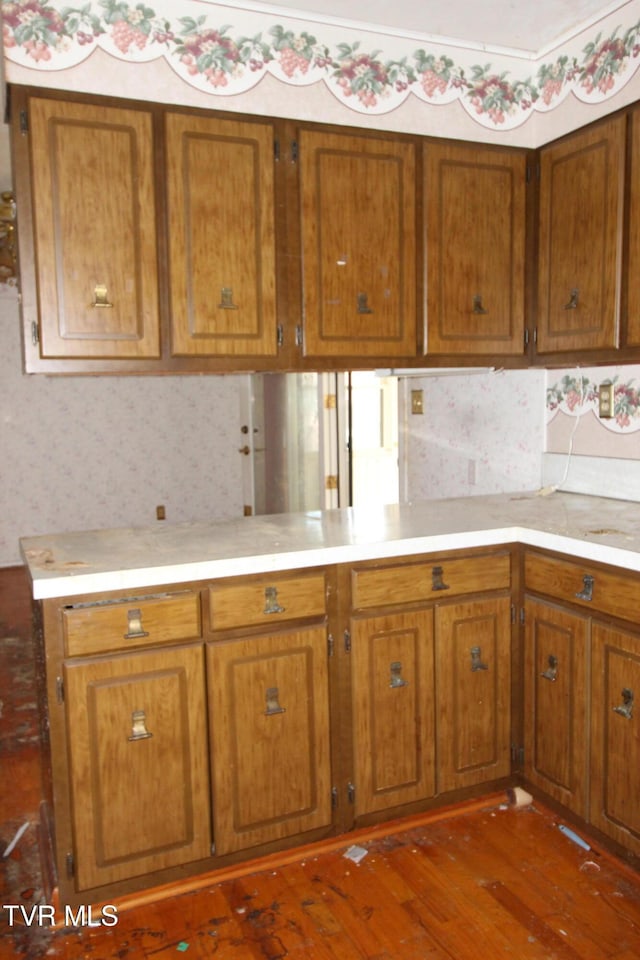 kitchen with dark hardwood / wood-style flooring and kitchen peninsula