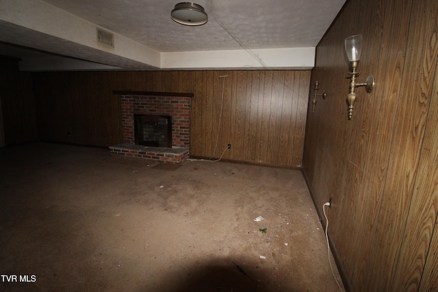 basement featuring a fireplace and wooden walls