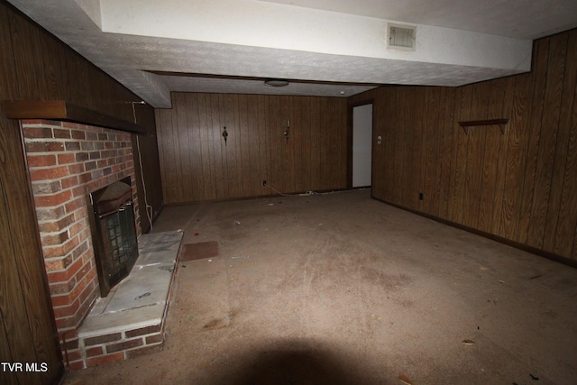 basement featuring a fireplace and wood walls