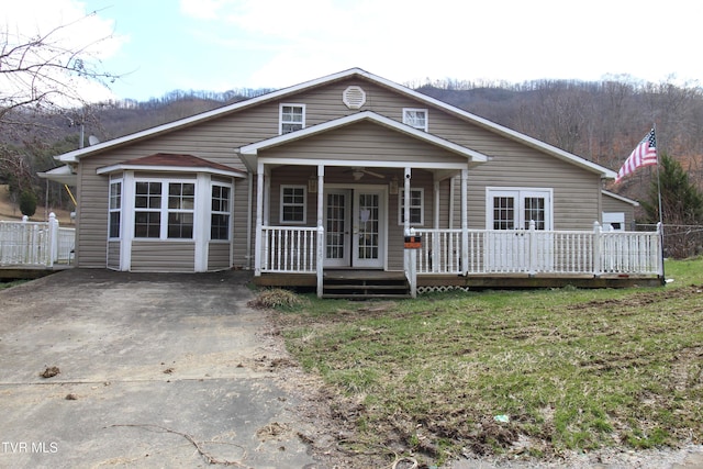 view of front of home with ceiling fan, a front lawn, and a porch