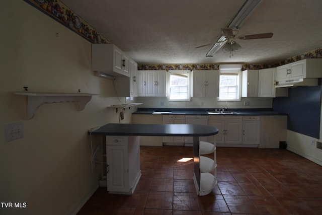 kitchen with white cabinets, sink, a kitchen breakfast bar, and kitchen peninsula