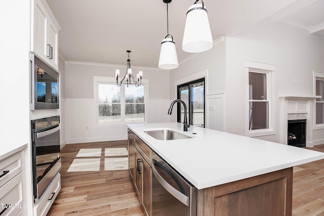 294 River Pointe Dr, Greeneville, TN 37743 - kitchen with crown molding, stainless steel appliances, light countertops, light wood-style floors, and a sink