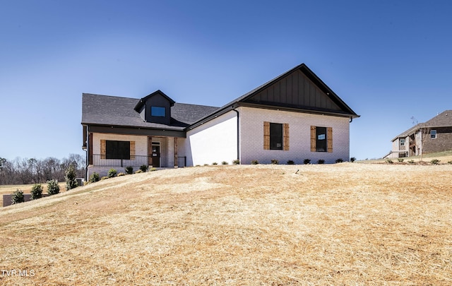 modern farmhouse featuring brick siding and board and batten siding