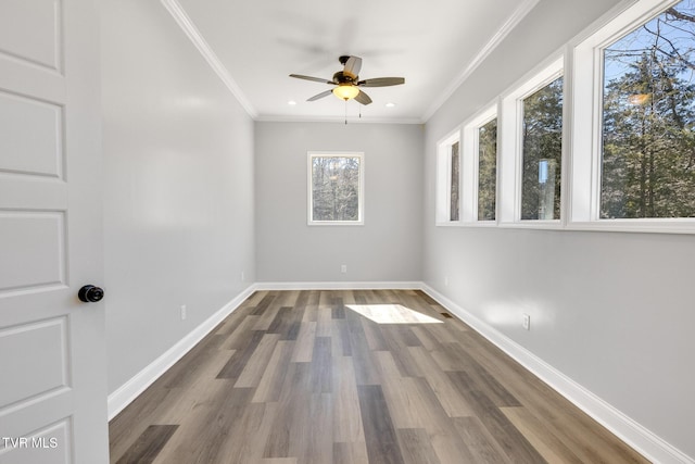 spare room featuring baseboards, ornamental molding, and wood finished floors