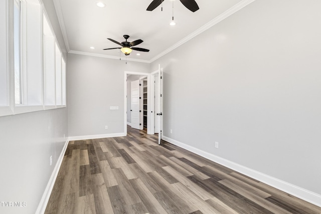 empty room featuring ornamental molding, recessed lighting, wood finished floors, and baseboards