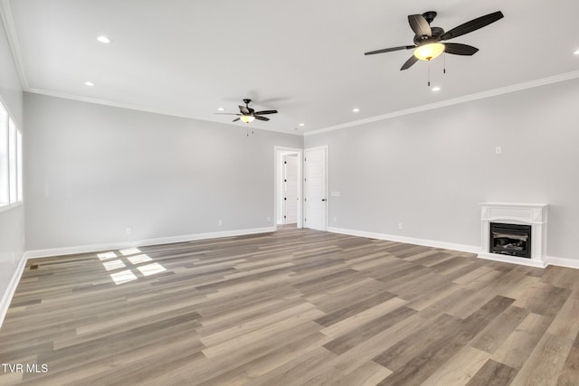 unfurnished living room featuring crown molding, a fireplace, light wood finished floors, recessed lighting, and baseboards