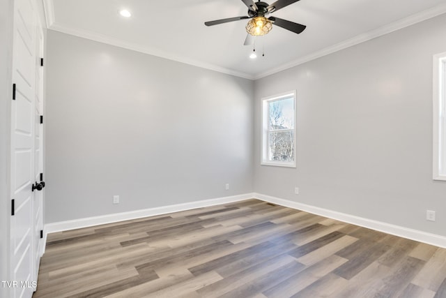 unfurnished room featuring crown molding, baseboards, and wood finished floors