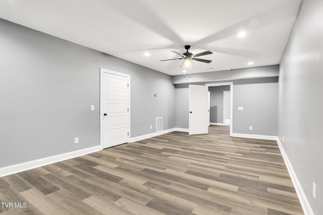 unfurnished bedroom with baseboards, wood finished floors, and recessed lighting