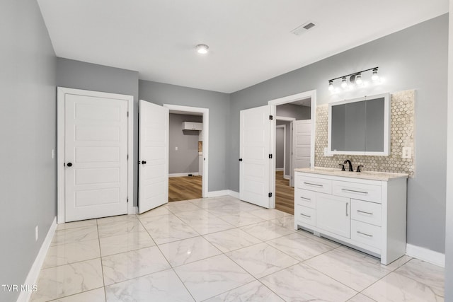 bathroom with tasteful backsplash, marble finish floor, visible vents, and baseboards