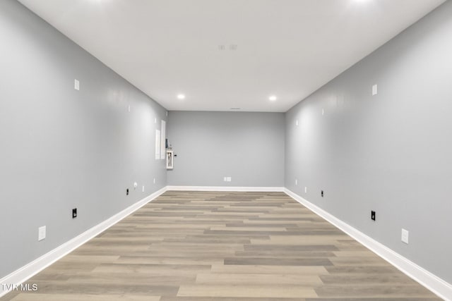 spare room with recessed lighting, light wood-type flooring, and baseboards