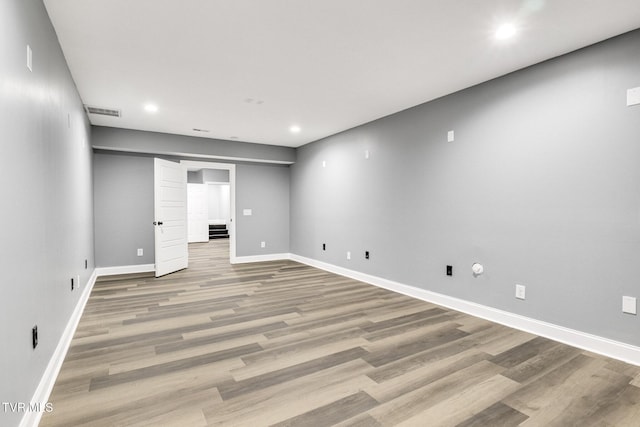 below grade area with visible vents, baseboards, wood finished floors, and recessed lighting