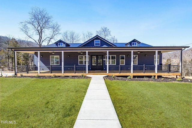 farmhouse featuring covered porch, ceiling fan, and a front yard