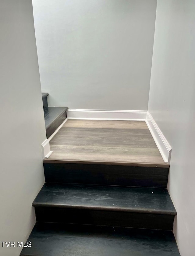 stairway featuring baseboards and wood finished floors