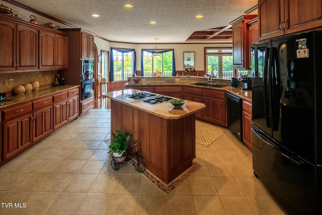 kitchen with a peninsula, black appliances, plenty of natural light, and a sink