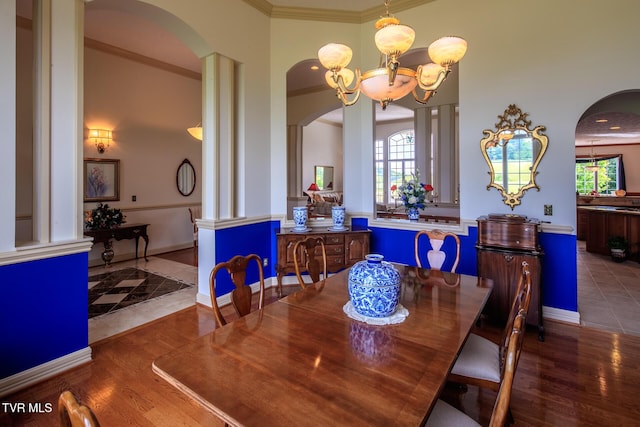 dining area featuring dark wood finished floors, crown molding, and baseboards