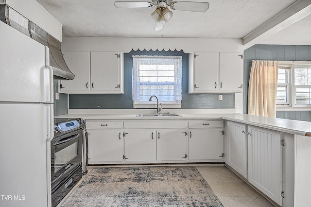 kitchen featuring plenty of natural light, range with electric cooktop, white refrigerator, sink, and white cabinetry