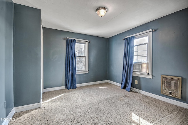 carpeted spare room featuring heating unit