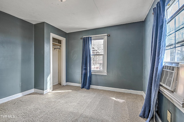 unfurnished bedroom with cooling unit, carpet floors, and a textured ceiling