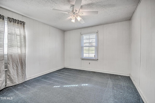 carpeted spare room featuring a textured ceiling and ceiling fan