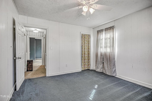 carpeted spare room with a textured ceiling and ceiling fan