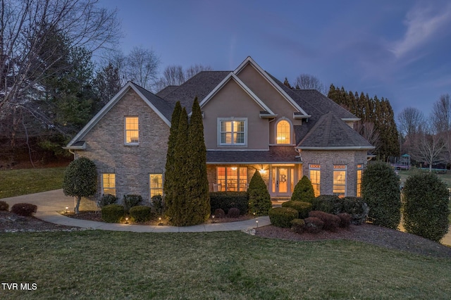 traditional-style home featuring a yard and stucco siding