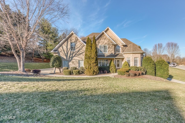 traditional-style house featuring a front lawn and brick siding